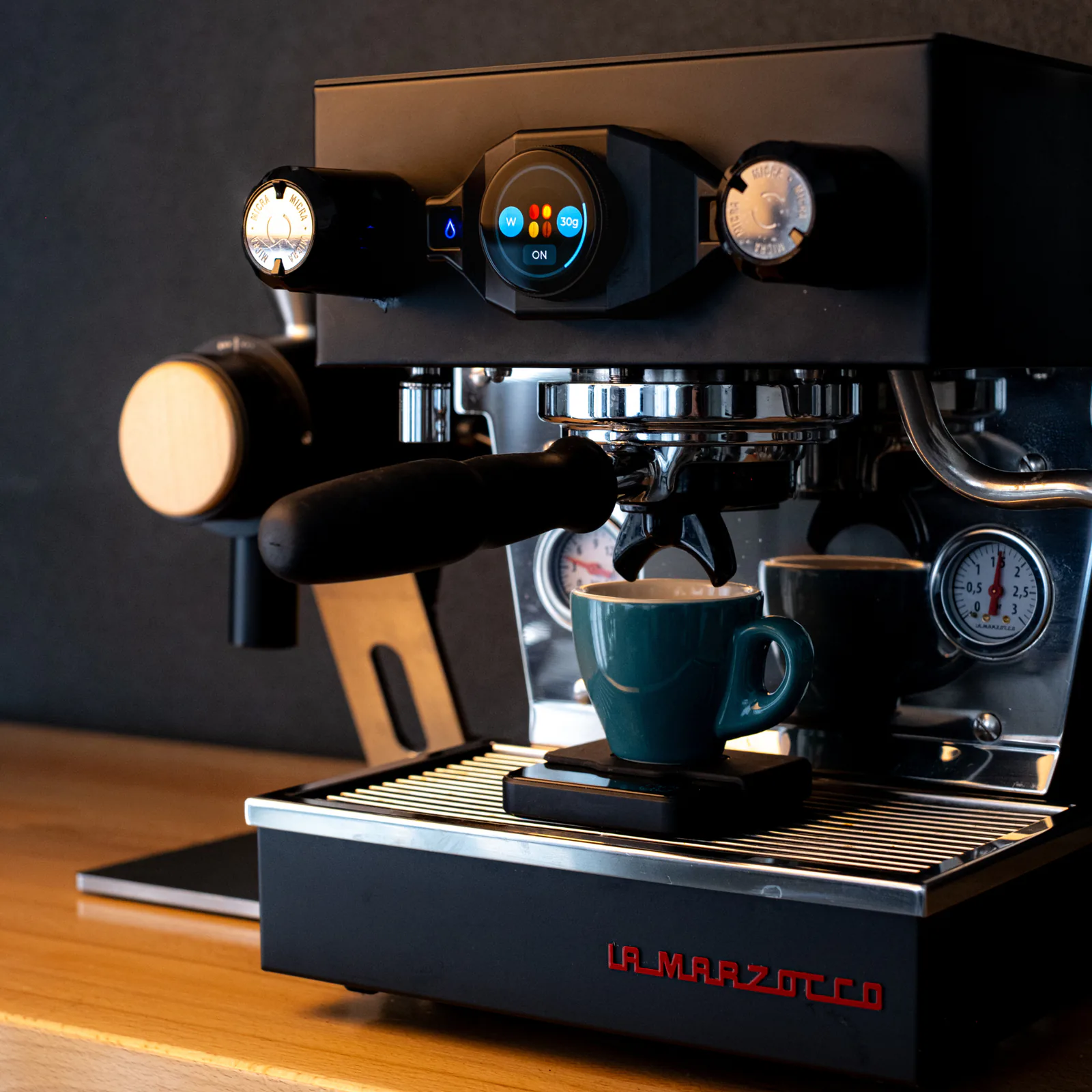 Espresso brewing into a teal cup